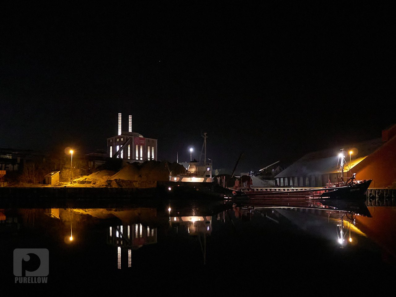 Skib i Næstved havn med Maglemølle Kraftcentral i baggrunden